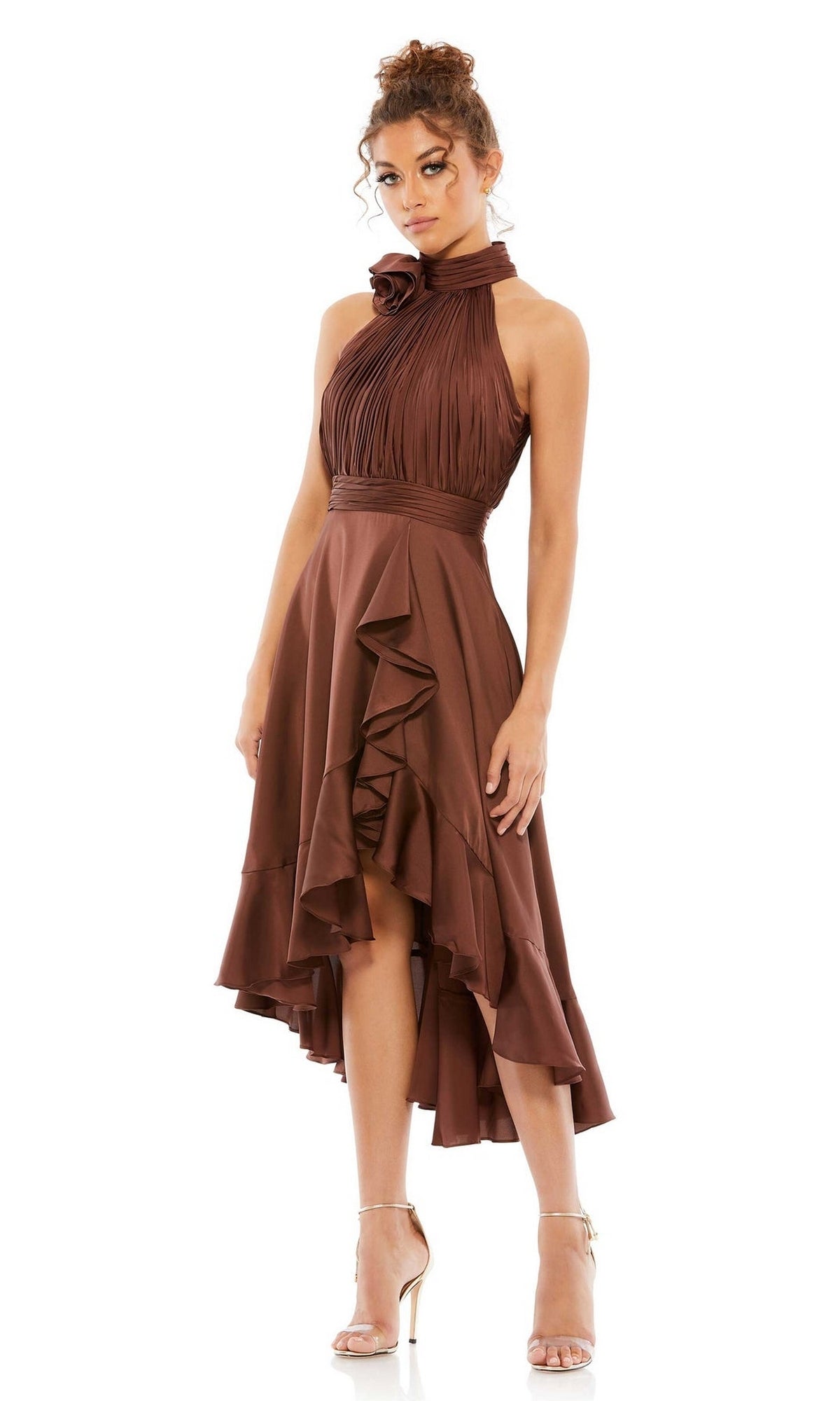 A woman wears the Mac Duggal 49488 High-Low Wedding Guest Dress with a high neck, ruffled details, and an asymmetrical hem, paired with strappy high-heeled sandals.